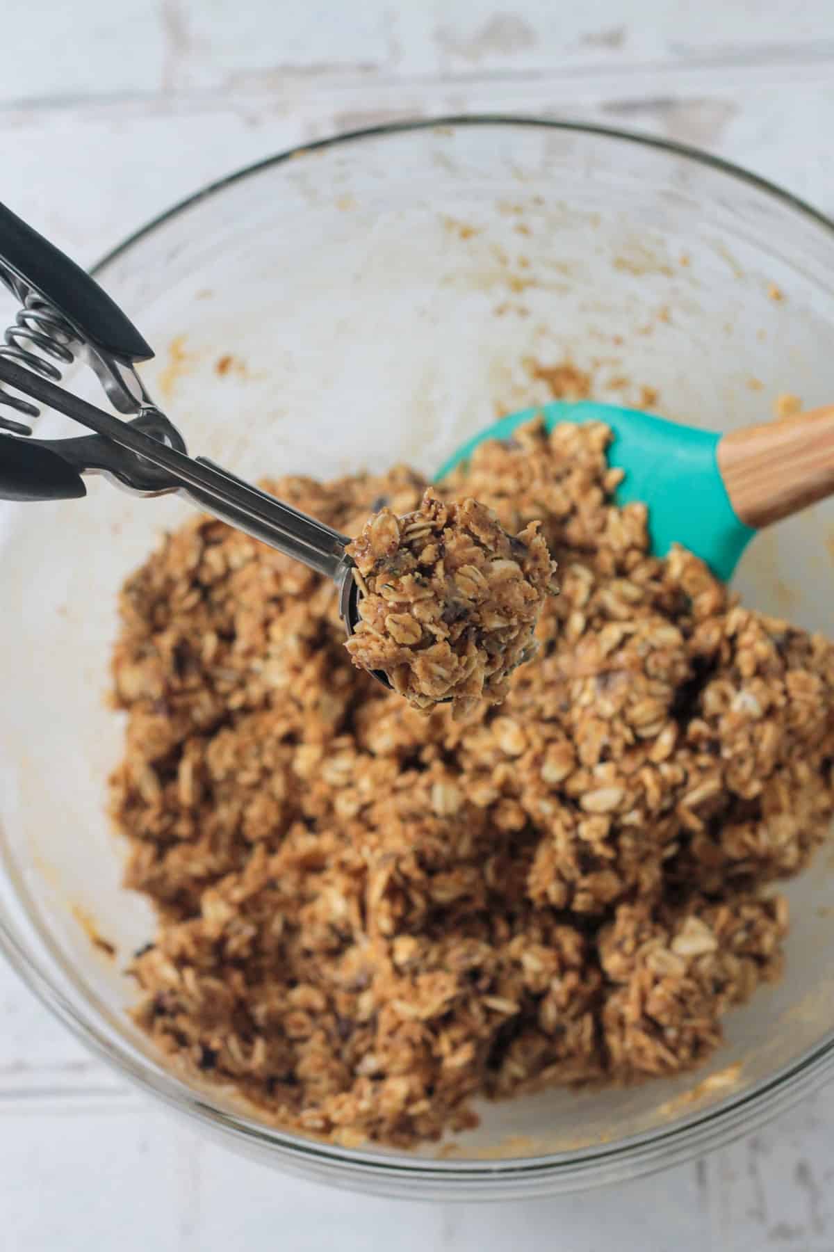 Small cookie scoop in a bowl of dough.