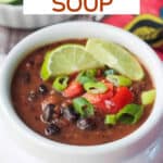 Bowl of vegan black bean soup with a bowl of lime wedges.