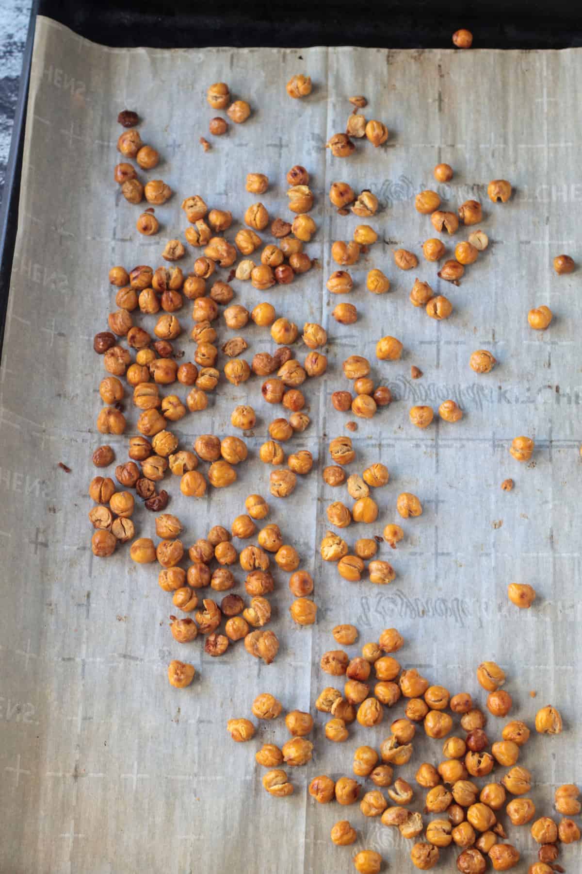 Chickpea roasted on a parchment lined baking sheet.