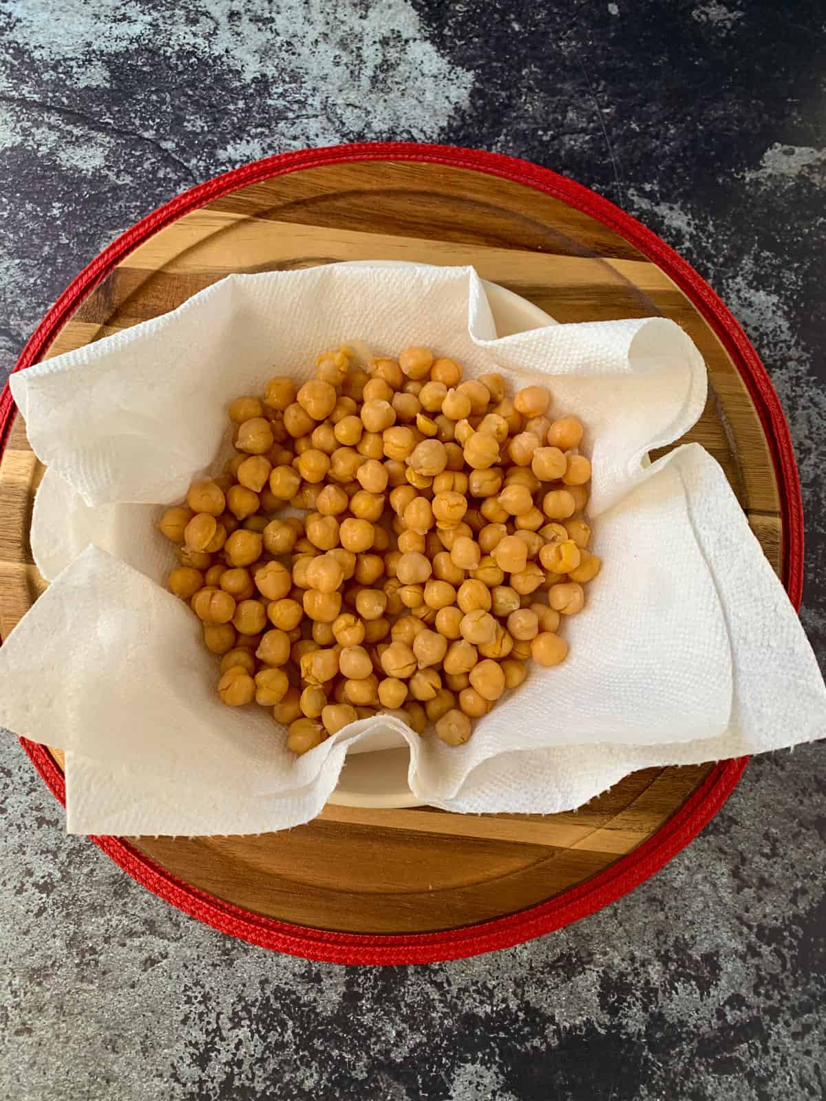 Drained chickpeas in a paper towel lined bowl.