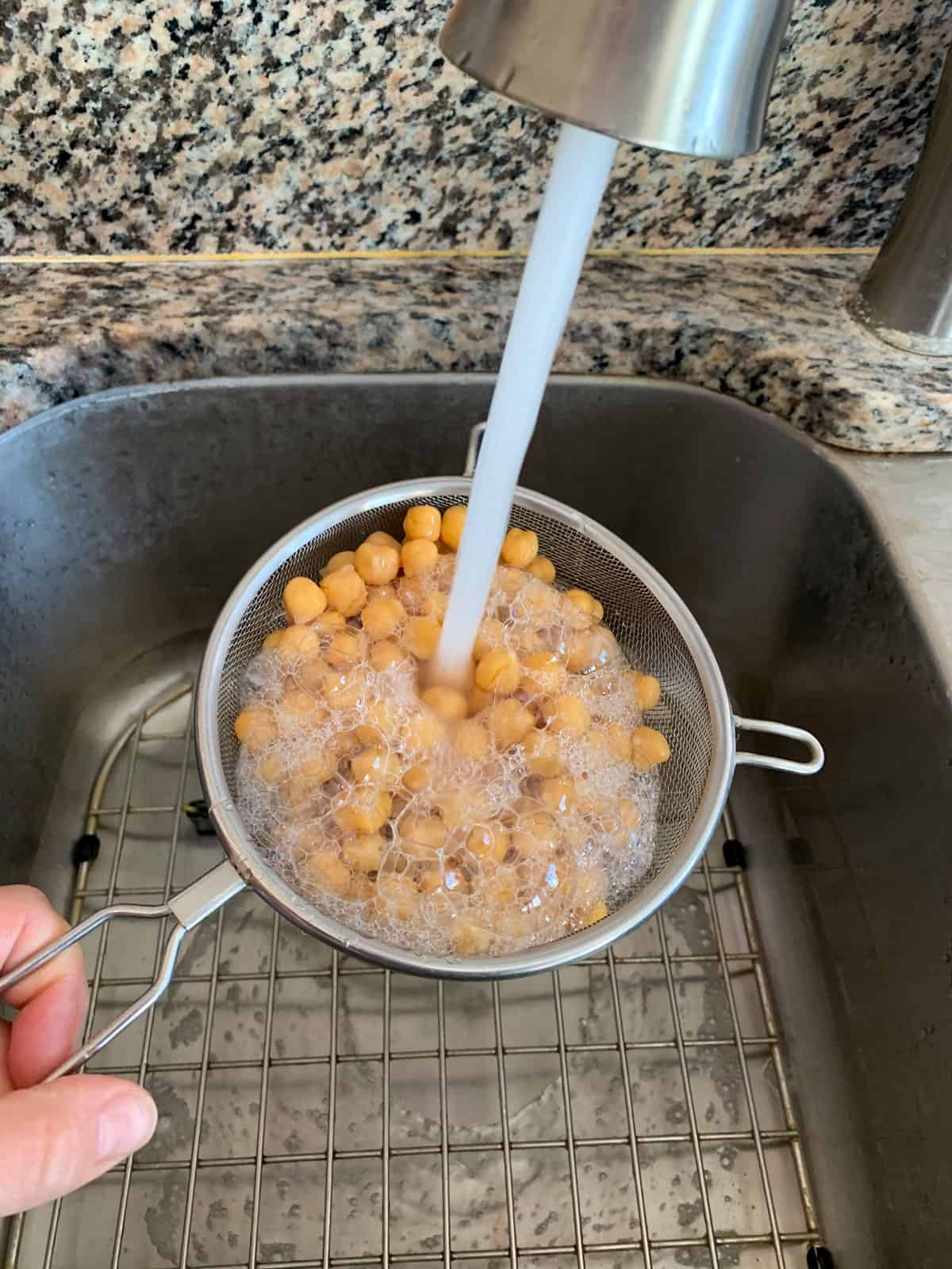 Rinsing chickpeas in a colandar.