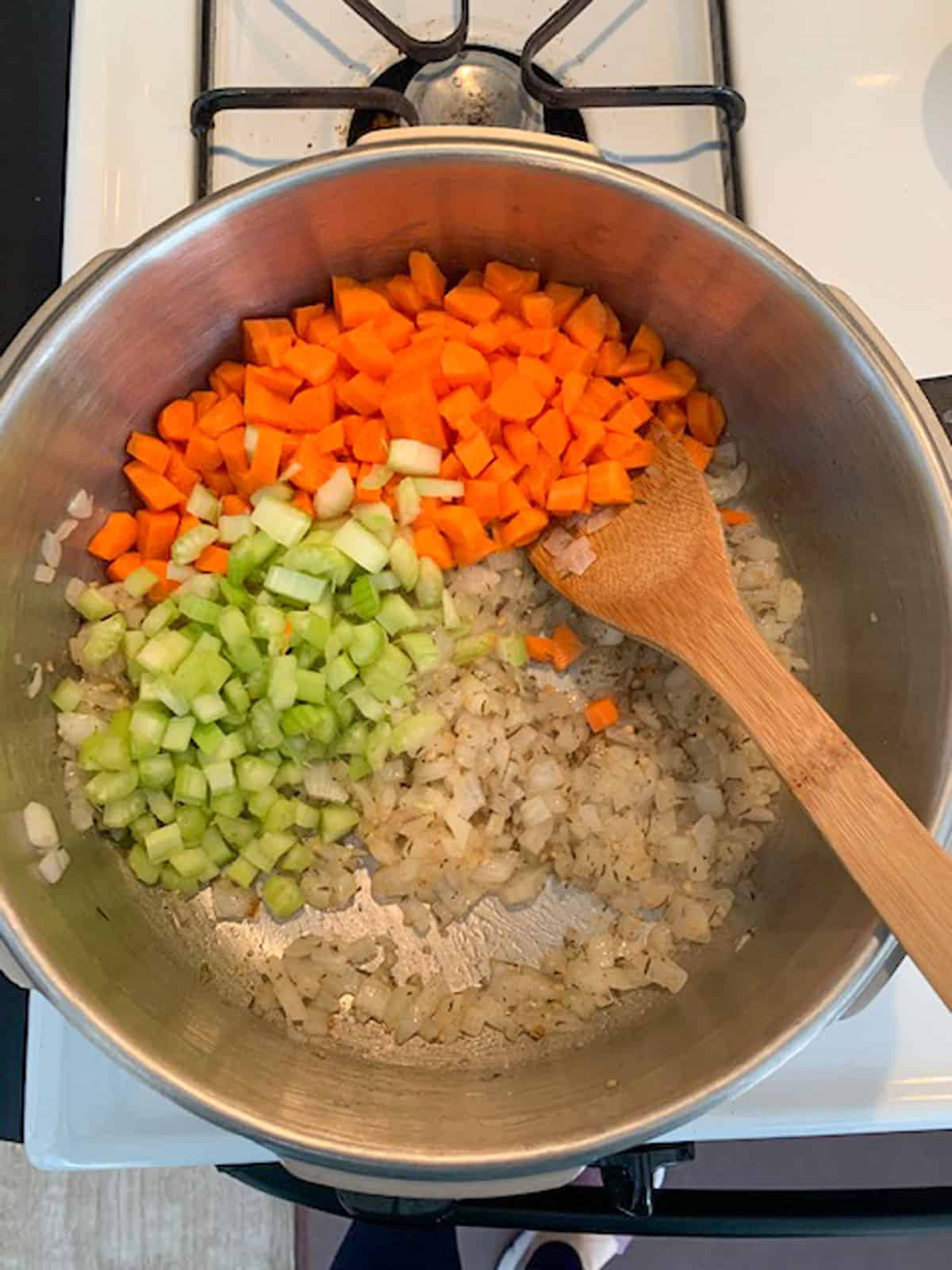 Adding diced vegetables to the pot.