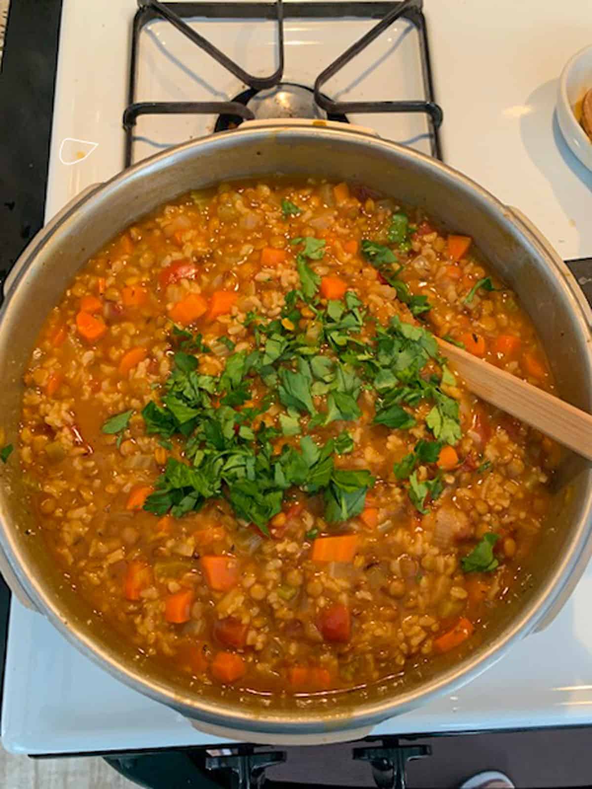 Adding chopped parsley to the finished soup.