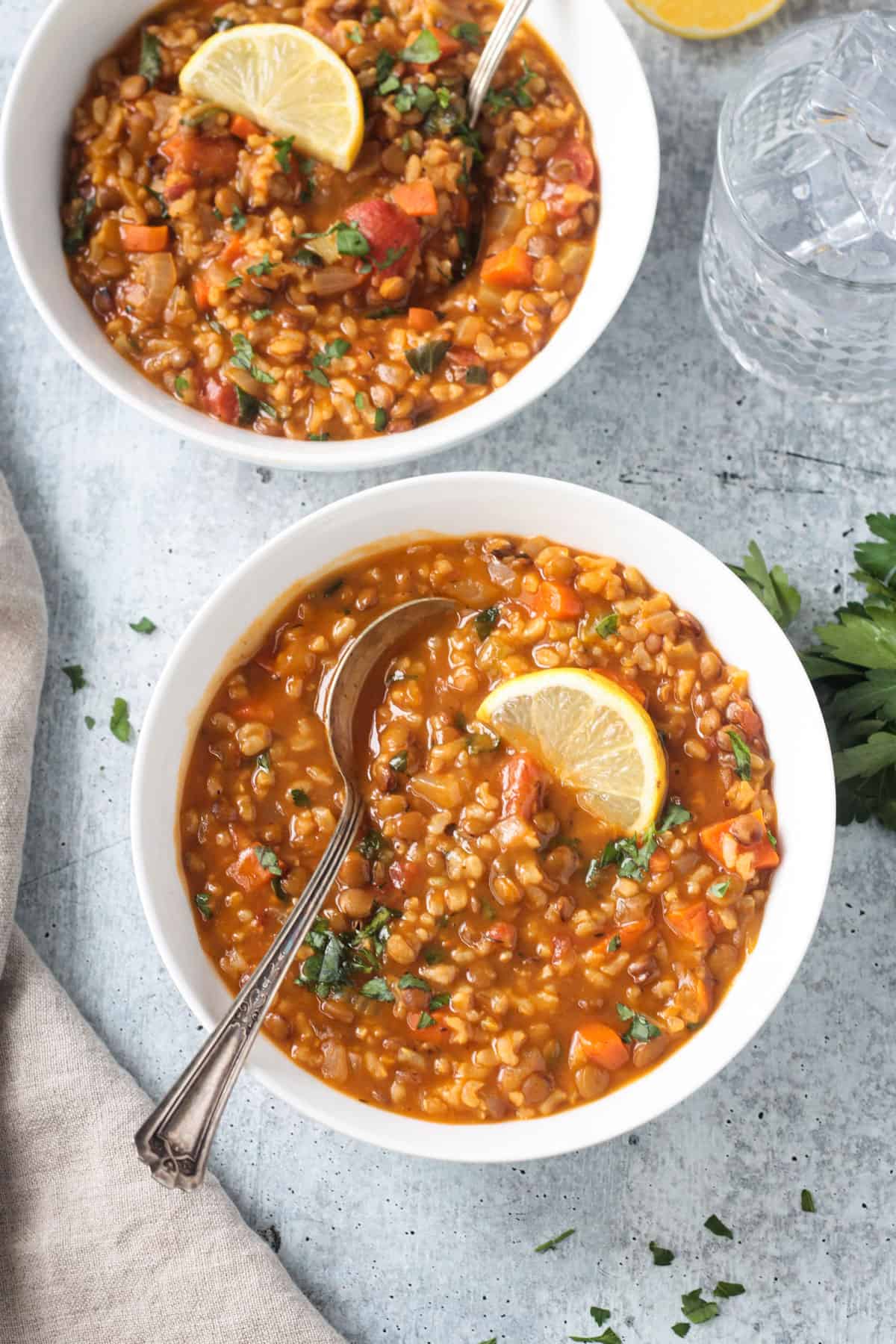 Two bowls of lentil rice soup on a table.