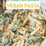 Creamy spinach artichoke sauce mixed with penne pasta in a pot.