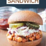 BBQ Chickpea Sandwich topped with creamy coleslaw and pickles on a whole wheat bun.