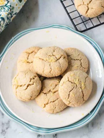 Pile of Lemon Crinkle Cookies on a white plate.