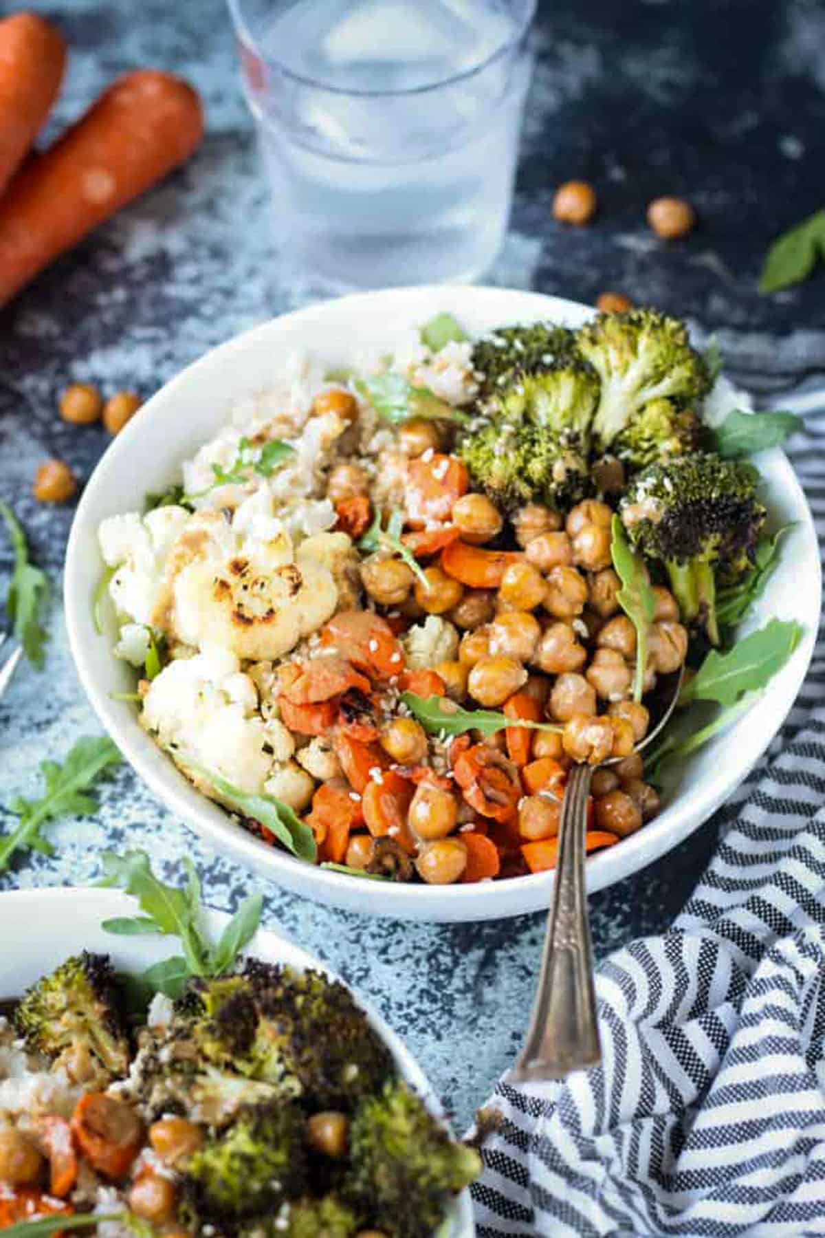 A metal spoon scooping up chickpeas from the veggie rice bowls.