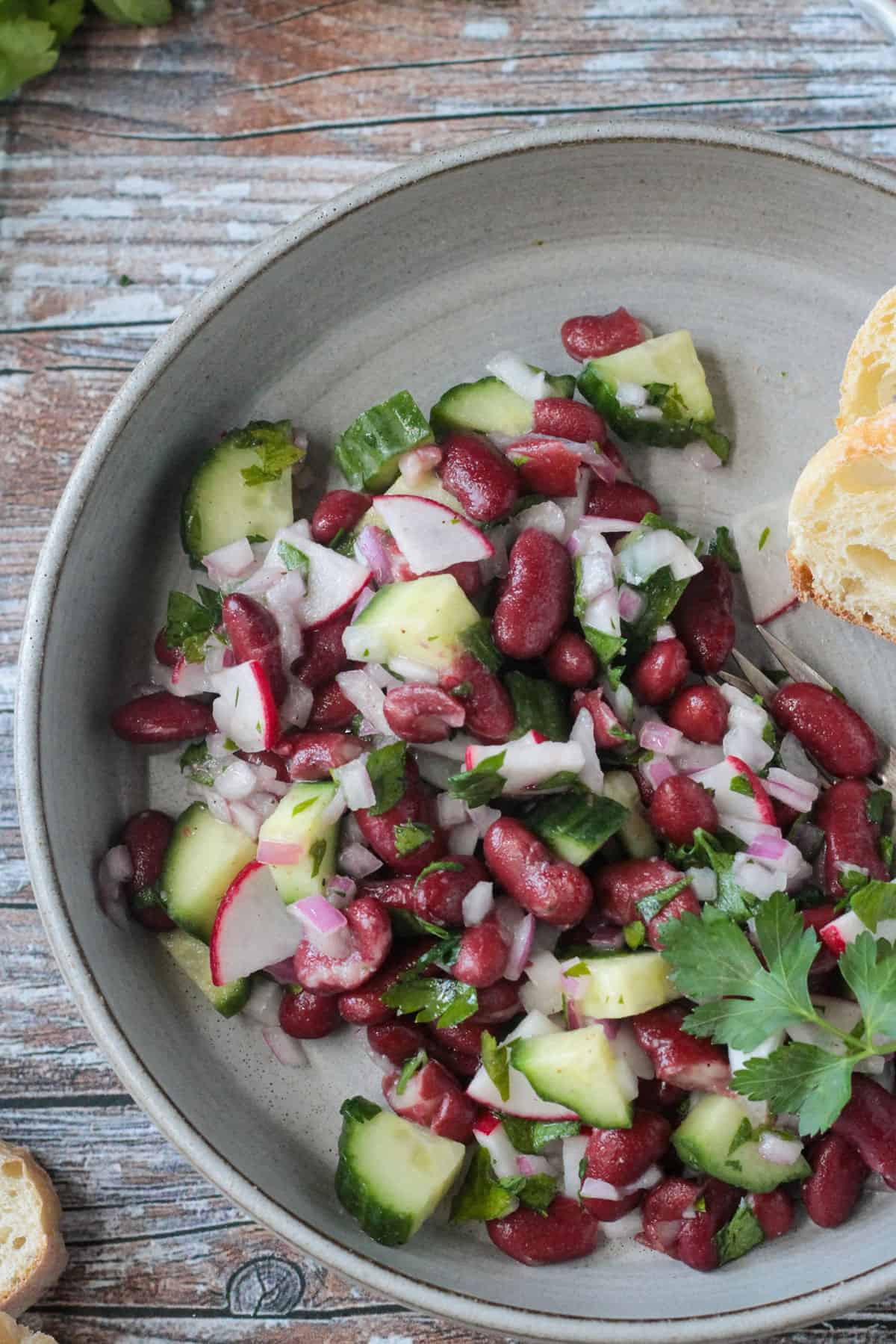 Close up overhead view of bean and veggie salad on a plate.