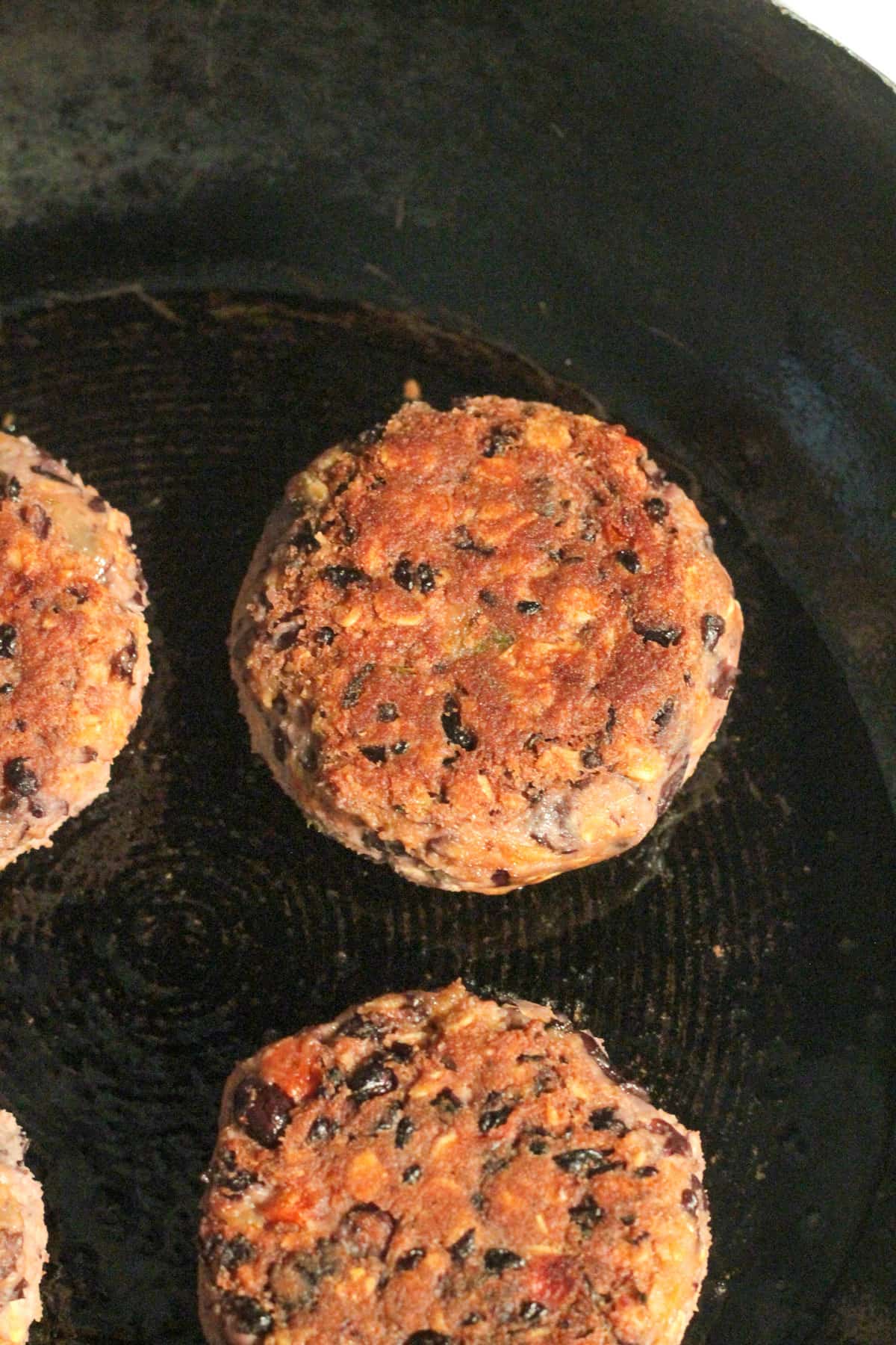 Close up of a cooked burger patty in the pan.