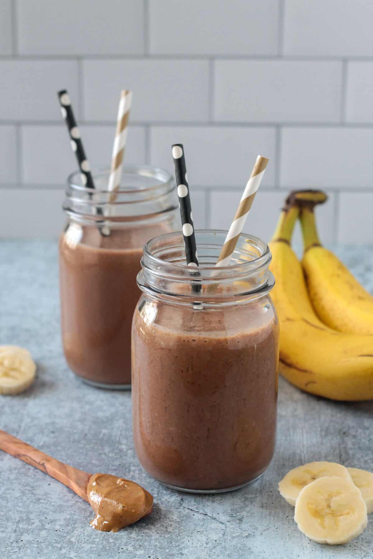 Two glasses filled with a chocolate drink.