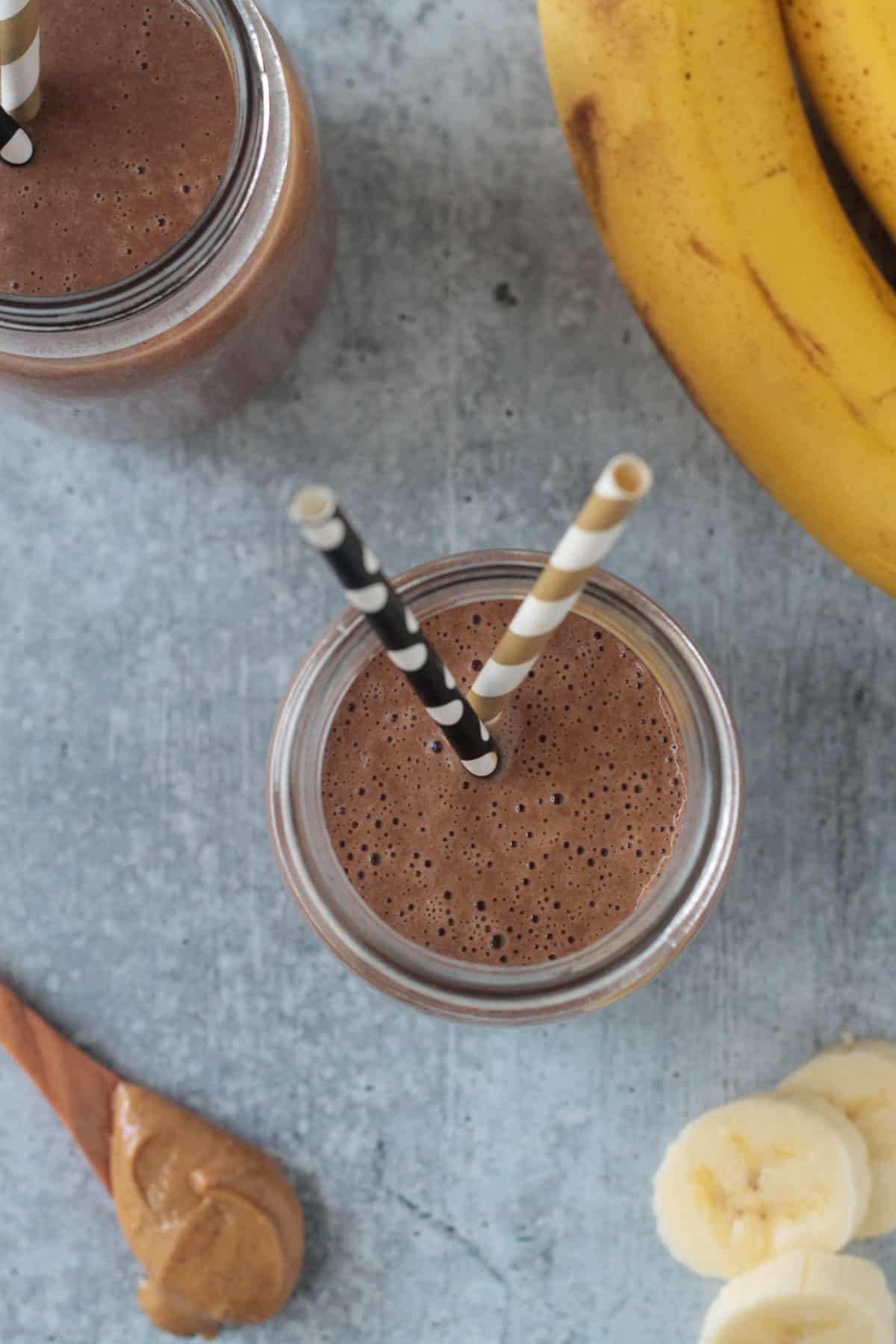 Two straws in a glass with a smoothie.