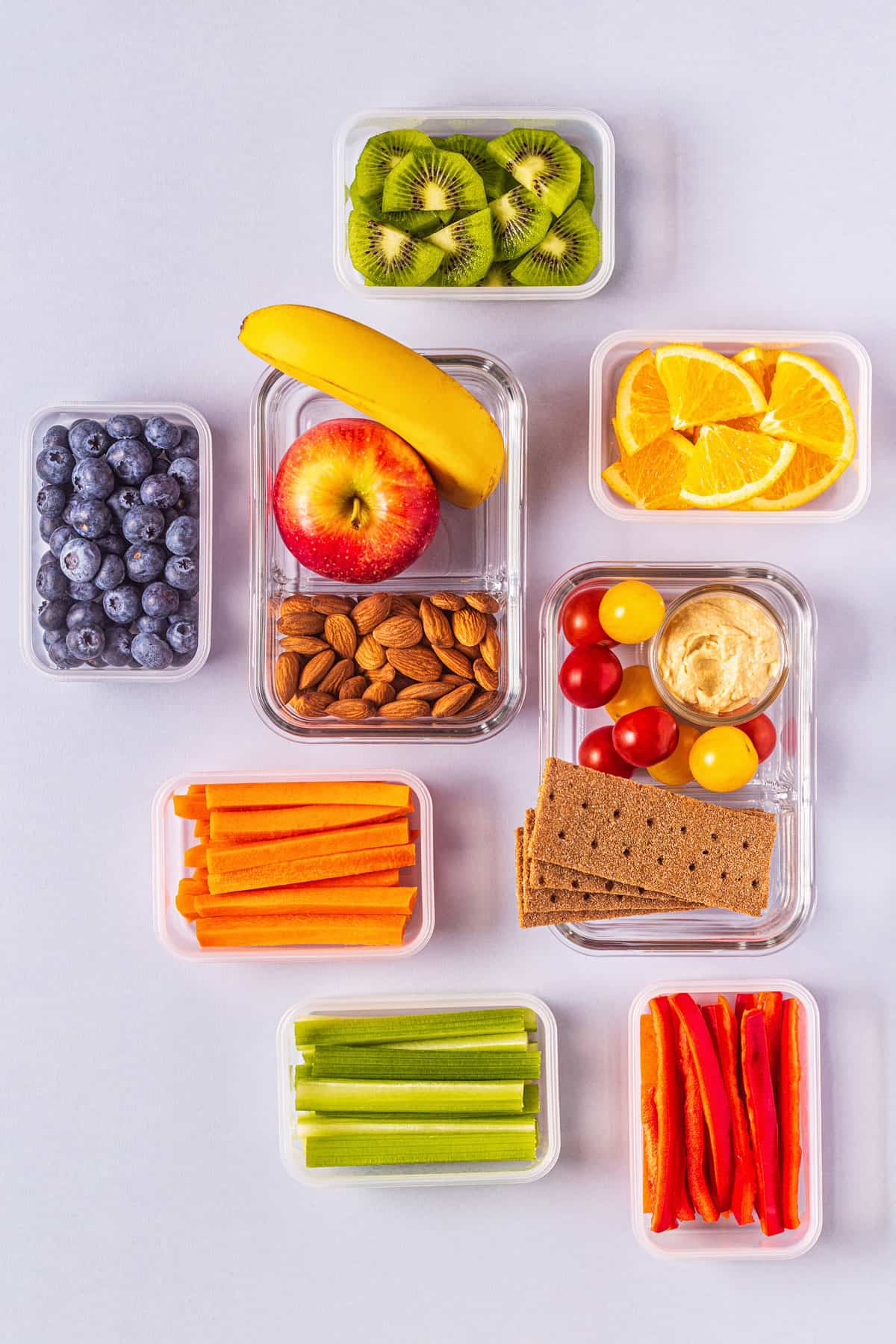 Collage of fruits and vegetables in lunch box containers.