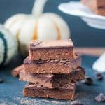 Stack of 4 vegan pumpkin brownies on a black slate board.