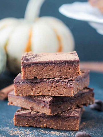 Stack of 4 vegan pumpkin brownies on a black slate board.