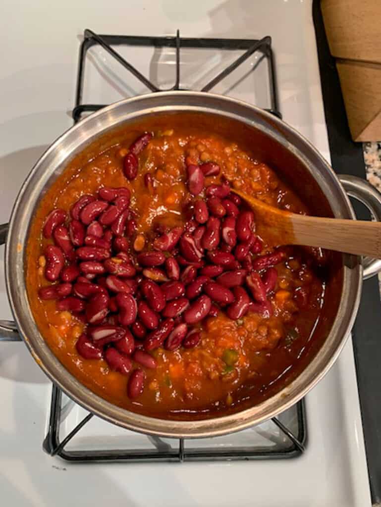 Adding kidney beans to the chili.