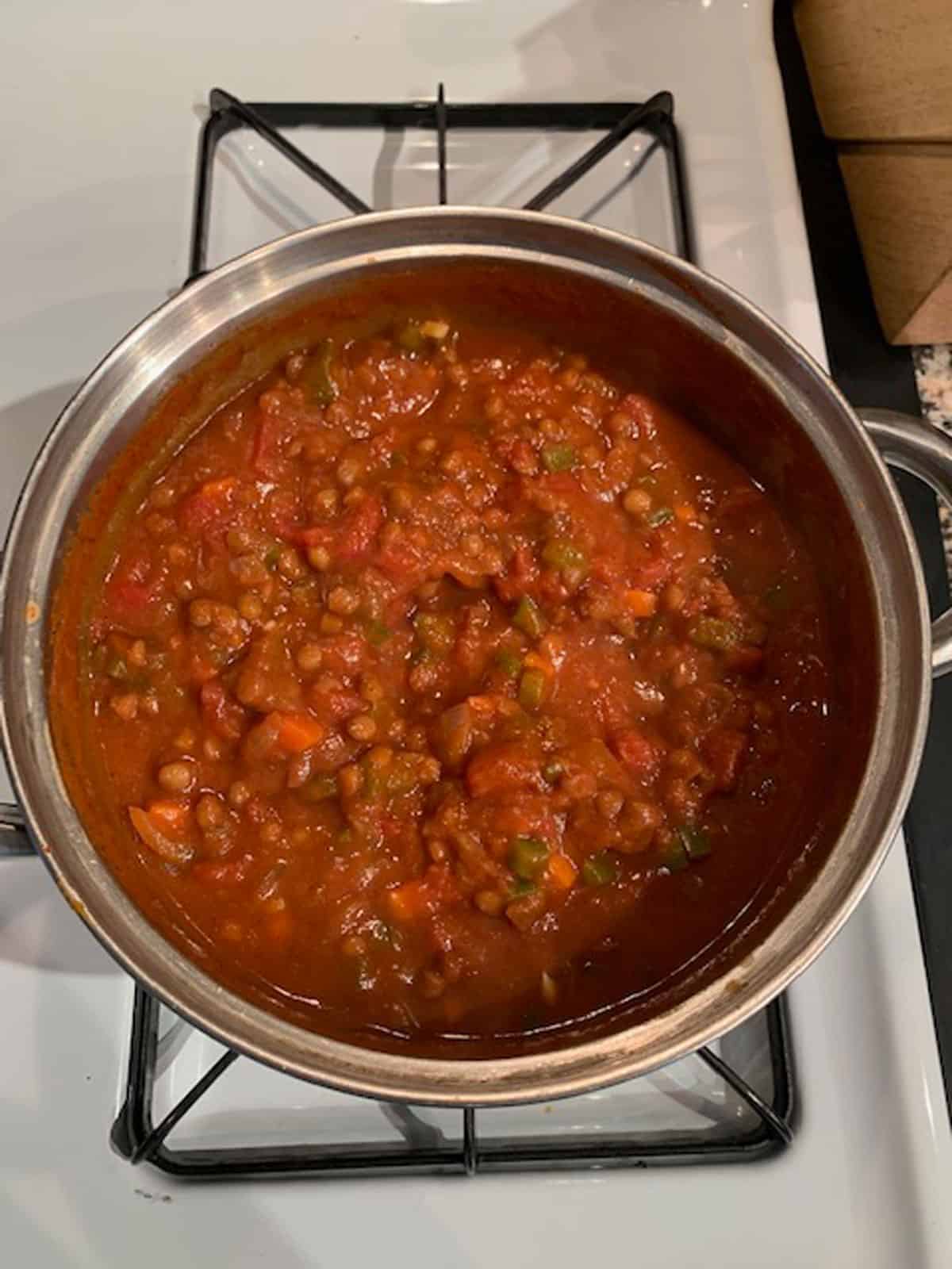 Vegan pumpkin chili simmered on the stove until thick.