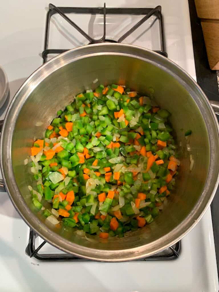 Diced carrots and peppers added to the sautéed onions.
