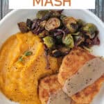 Two forks on a plate with butternut squash mash, brussels sprouts, vegan turkey cutlets, and gravy.