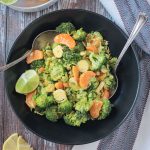 Vegan Brussels Sprouts Salad plated in a black bowl with two serving spoons.