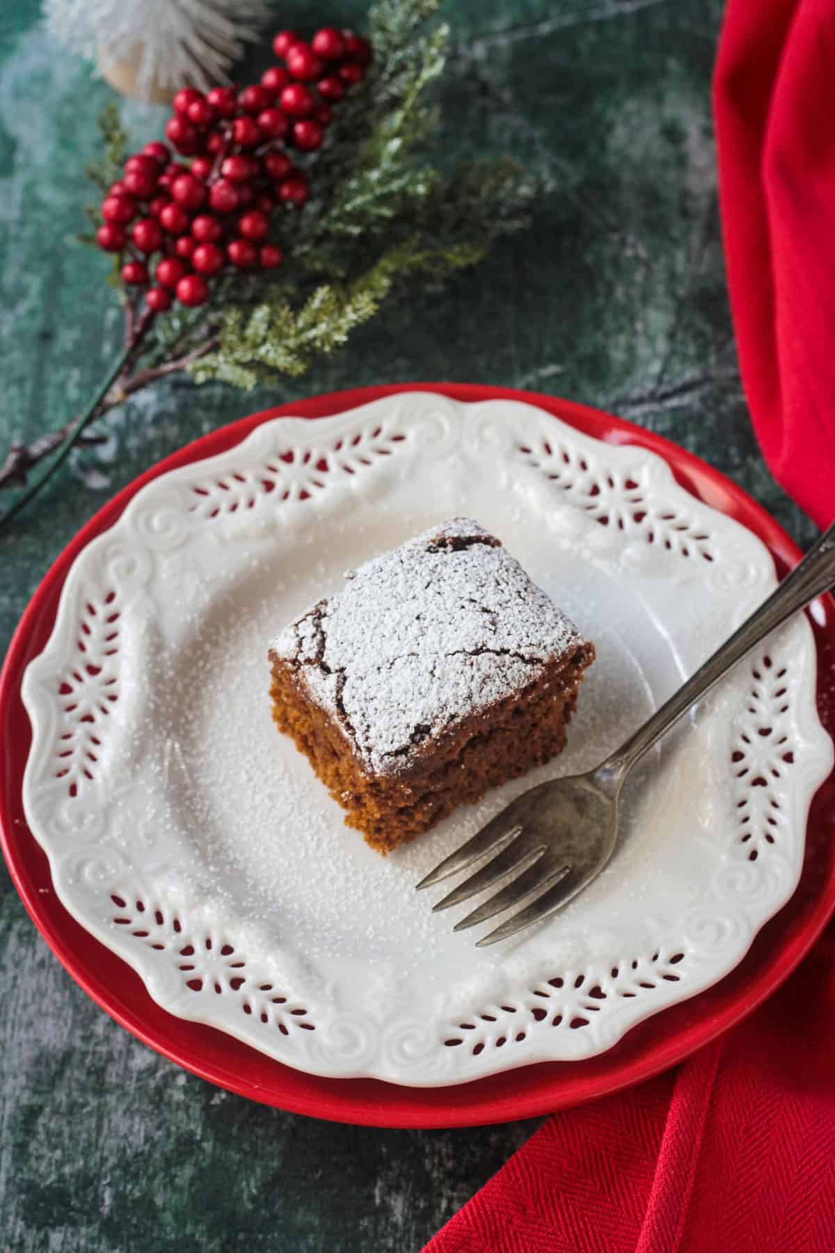 Powdered sugar dusted cake on a white plate with a fork.