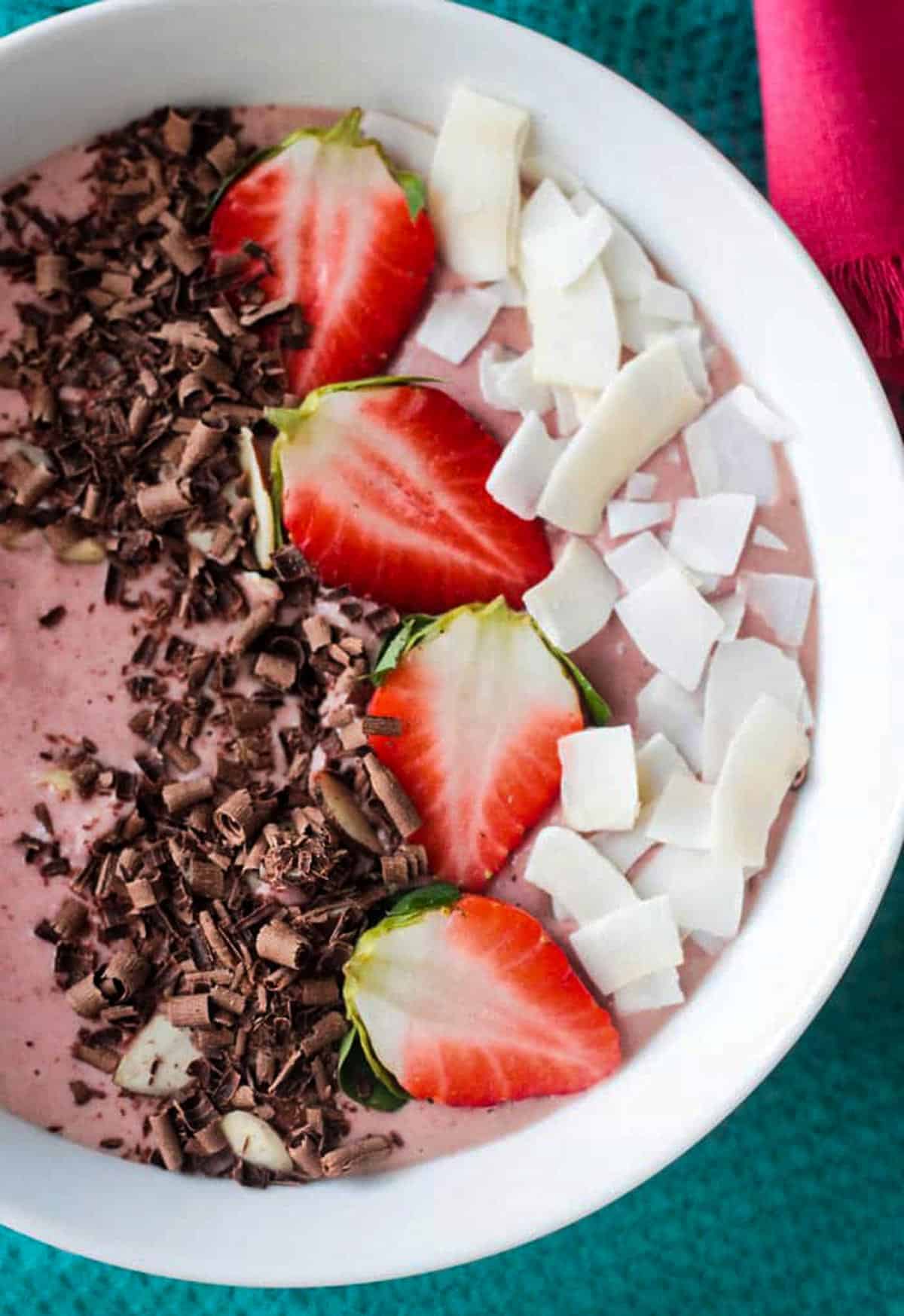 Close up of sliced strawberries, chocolate shavings, and coconut flakes.