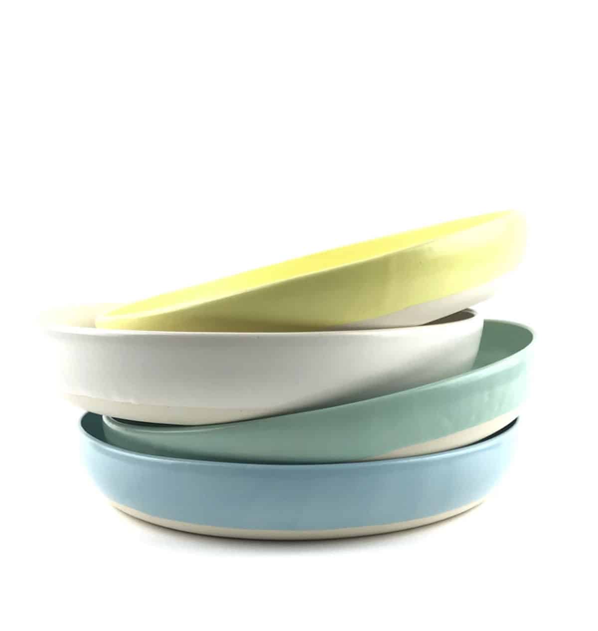 Stack of 4 colored flat bowls.