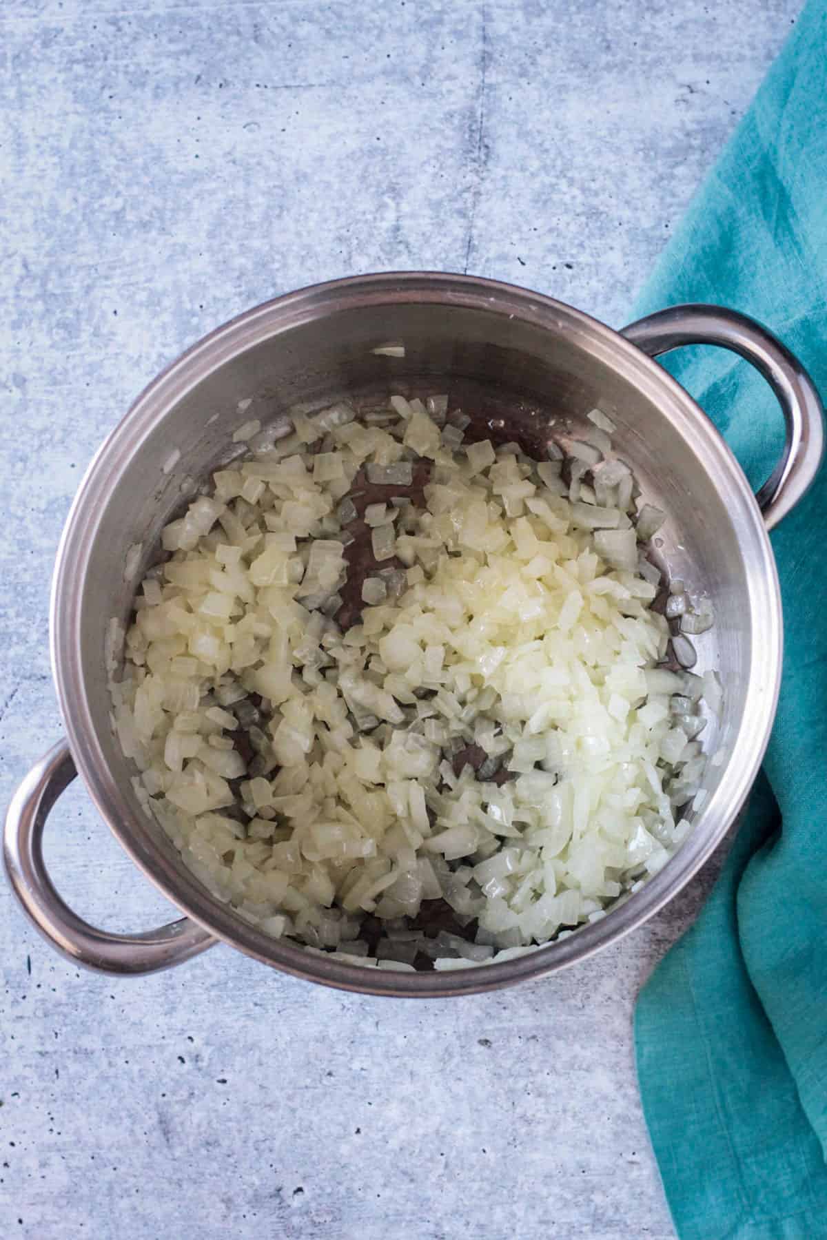 Onions sautéing in a soup pot.