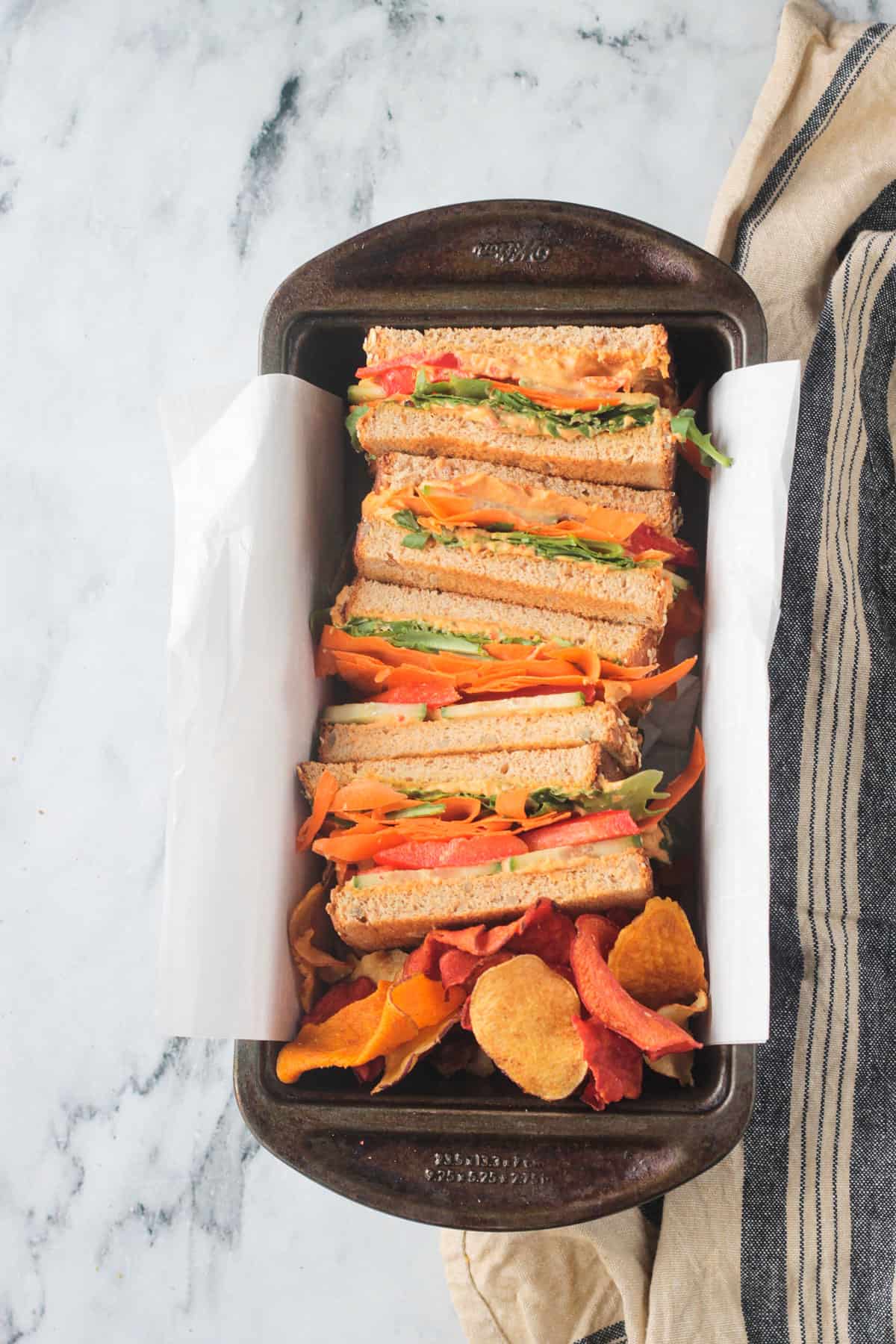 4 halves of a hummus sandwich, cut side up, in a loaf pan.