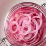 Overhead view of a jar of pickled red onions.