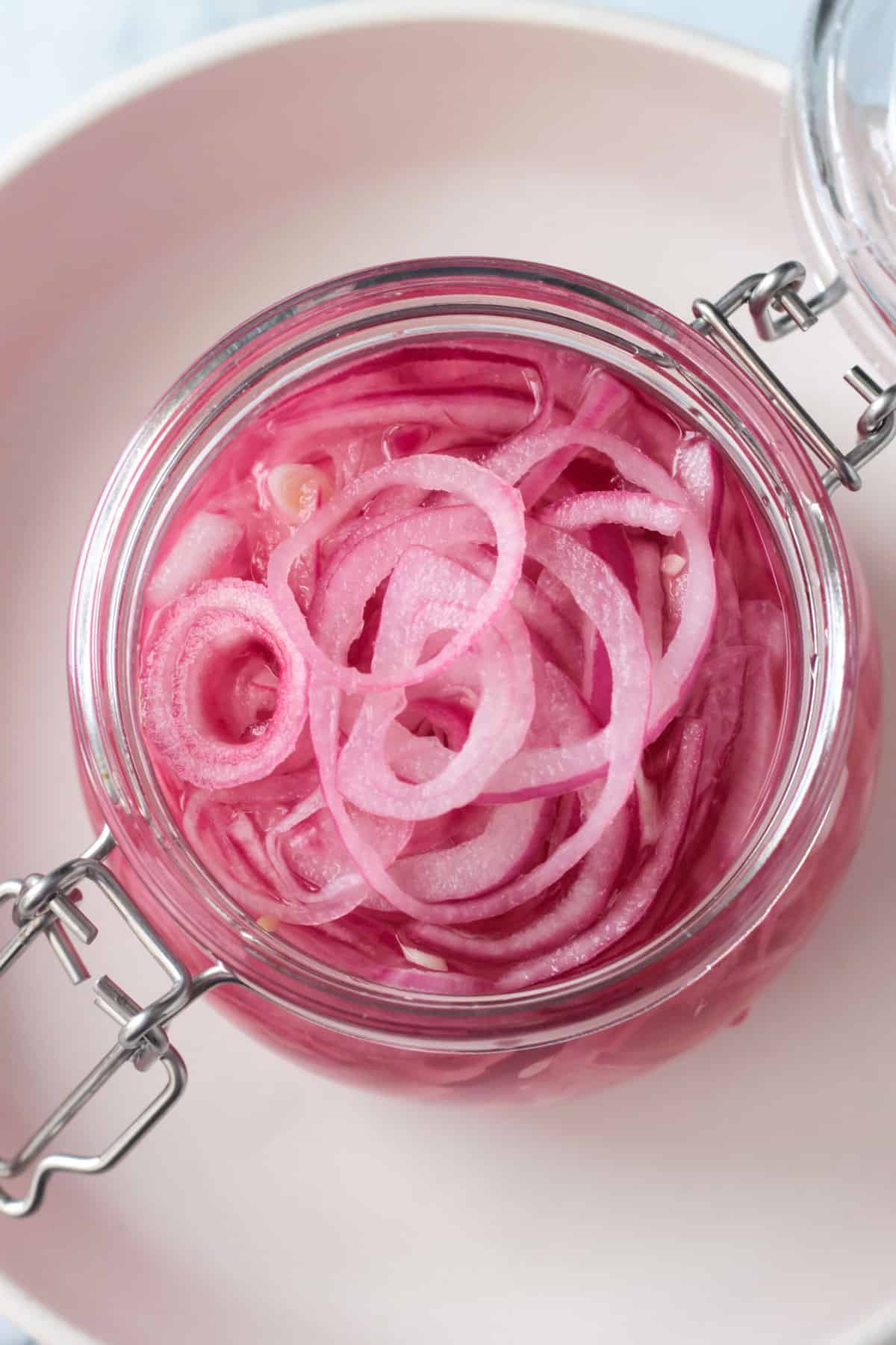 Overhead view of a jar of pickled red onions.