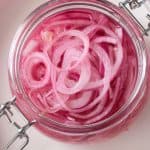 Overhead view of a jar of pickled red onions.