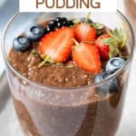Glass of chocolate chia pudding topped with fresh berries.