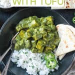 Vegan palak tofu and basmati rice in a black bowl with a side of naan.