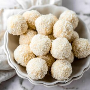 Pile of coconut truffles in a bowl.