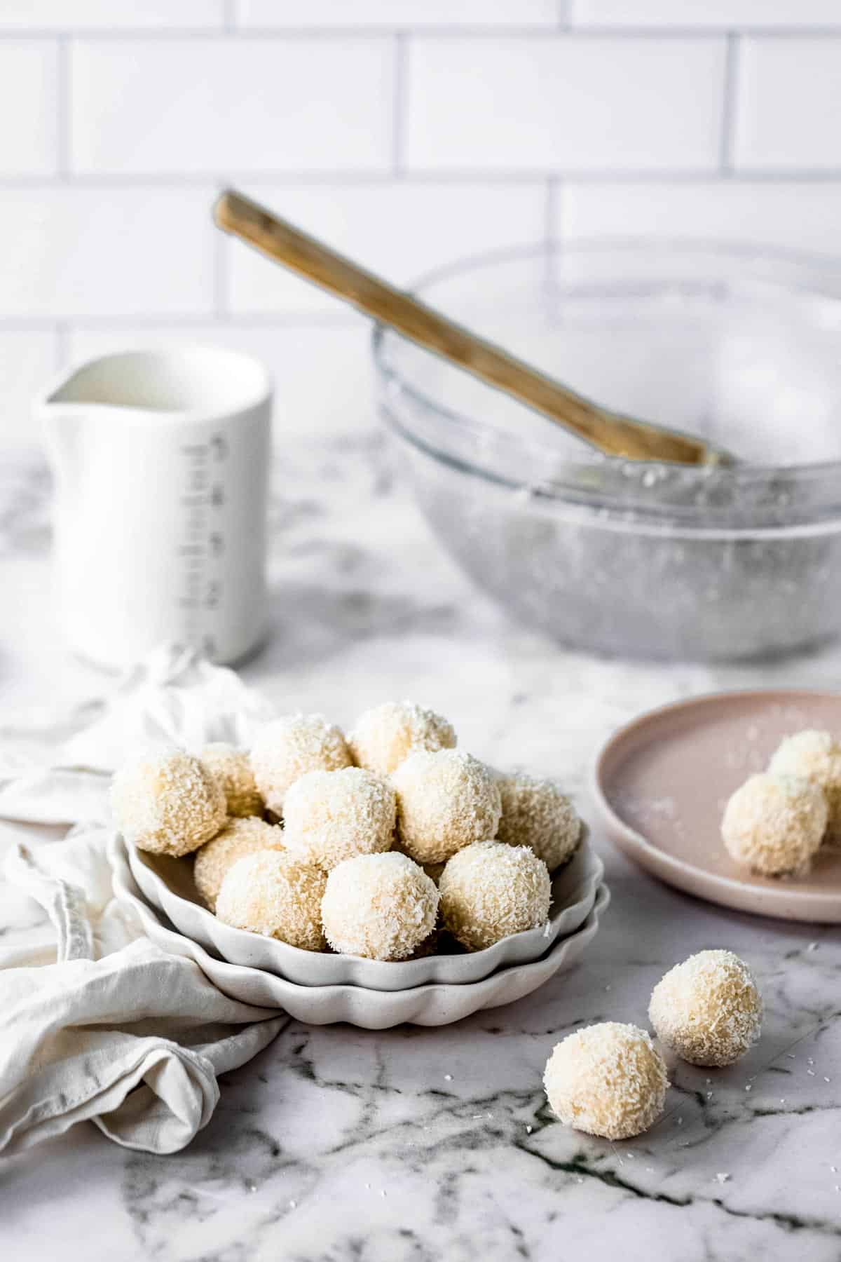 Kitchen counter with mixing bowl, measuring cup, and bowl of bite size dessert balls.