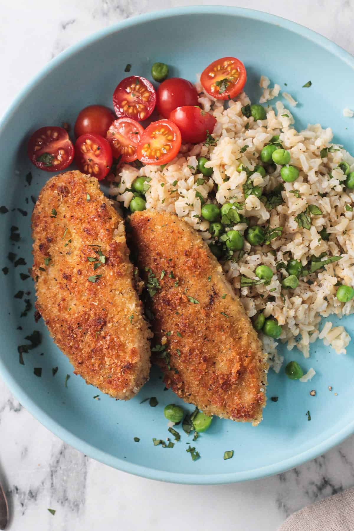 Close up of crispy breaded cutlets on a bed of rice.