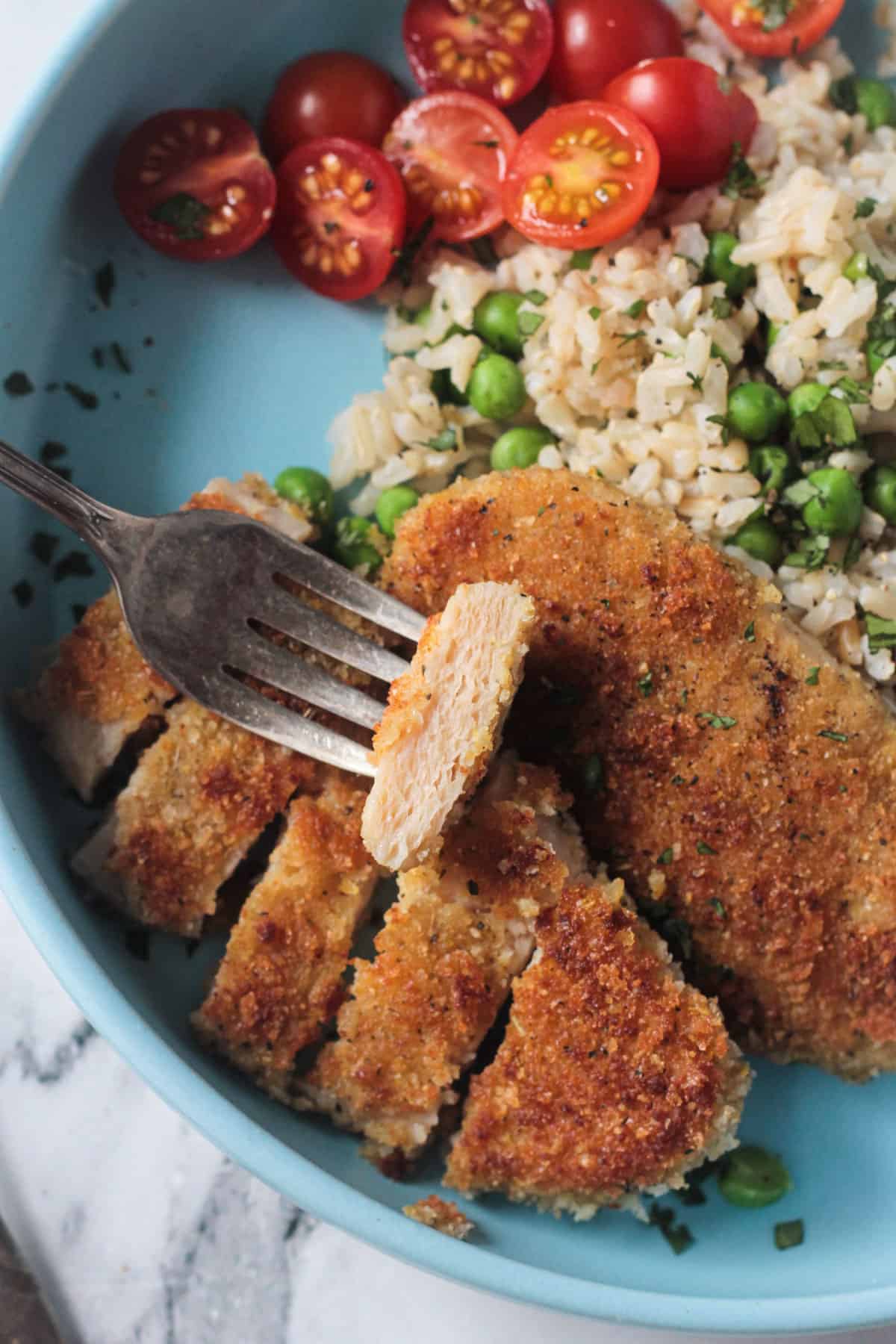 Close up of a slice of vegan chicken on a fork.