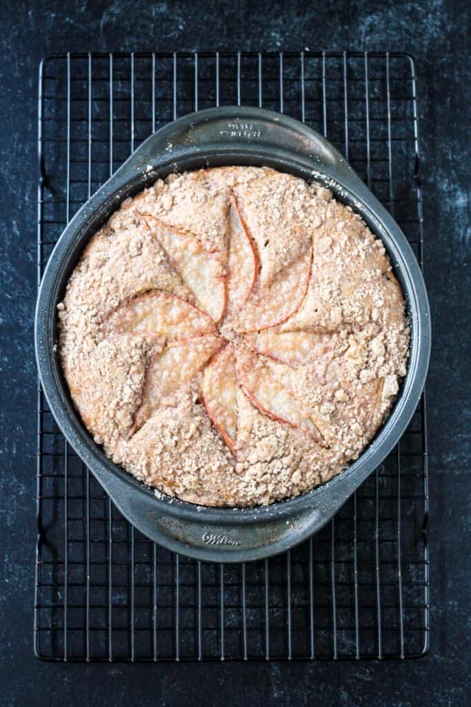 Baked vegan pear cake on a cooling rack.