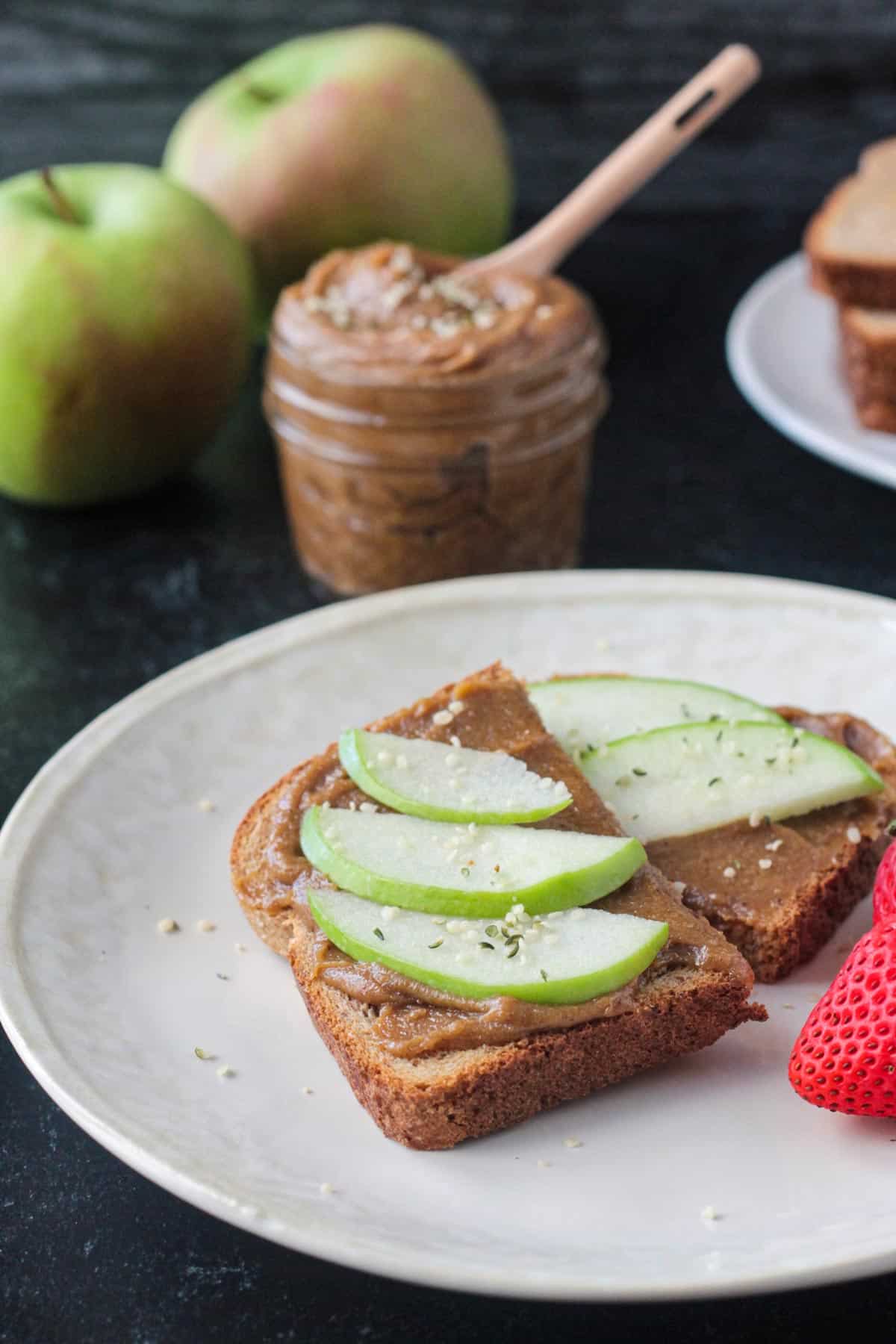Piece of toast with cookie butter spread and apple slices.