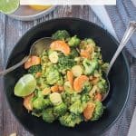 Vegan Brussels Sprouts Salad plated in a black bowl with two serving spoons.