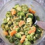 Large mixing bowl of brussels sprouts, broccoli, and oranges.