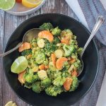 Vegan Brussels Sprouts Salad plated in a black bowl with two serving spoons.