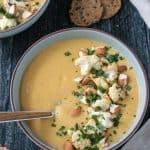 Bowl of creamy vegan cauliflower soup topped with roasted cauliflower and sliced almonds.