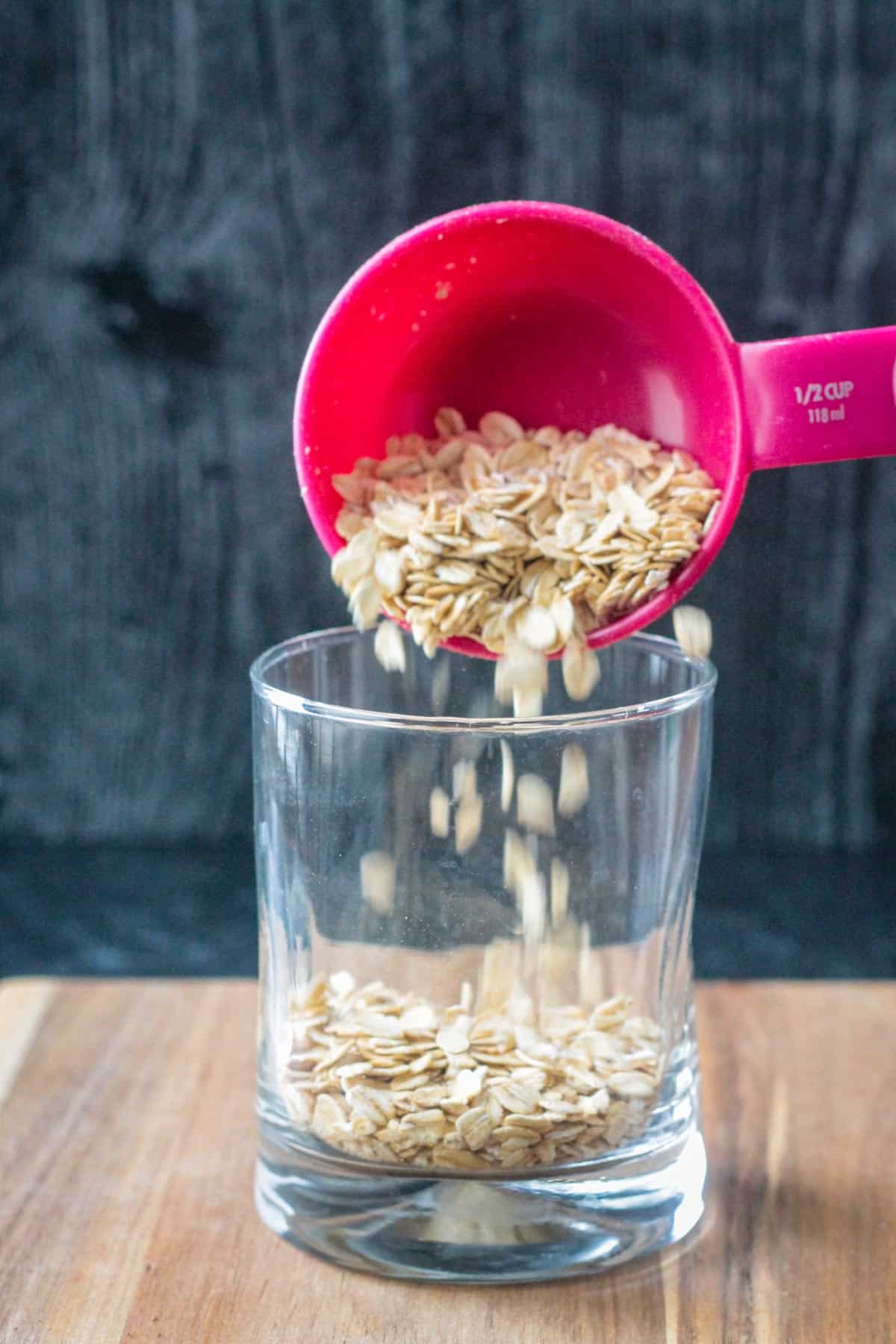 Pour raw oats into a glass.