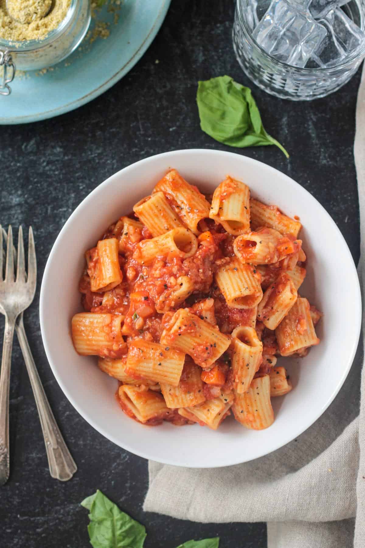 Rigatoni noodles with vegan cauliflower bolognese in a white bowl.