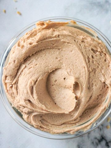 Peanut butter frosting spread in a glass bowl.