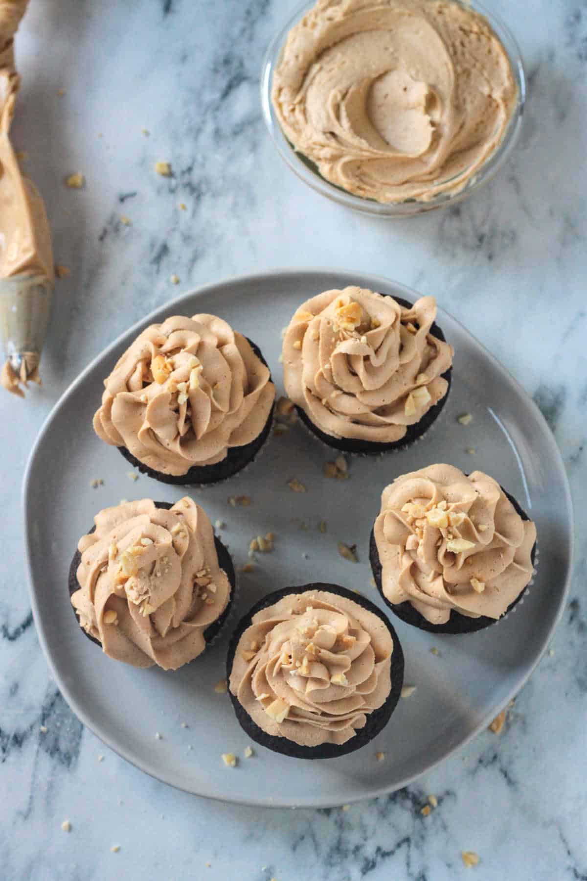 Cupcakes topped with vegan peanut butter frosting on a plate.