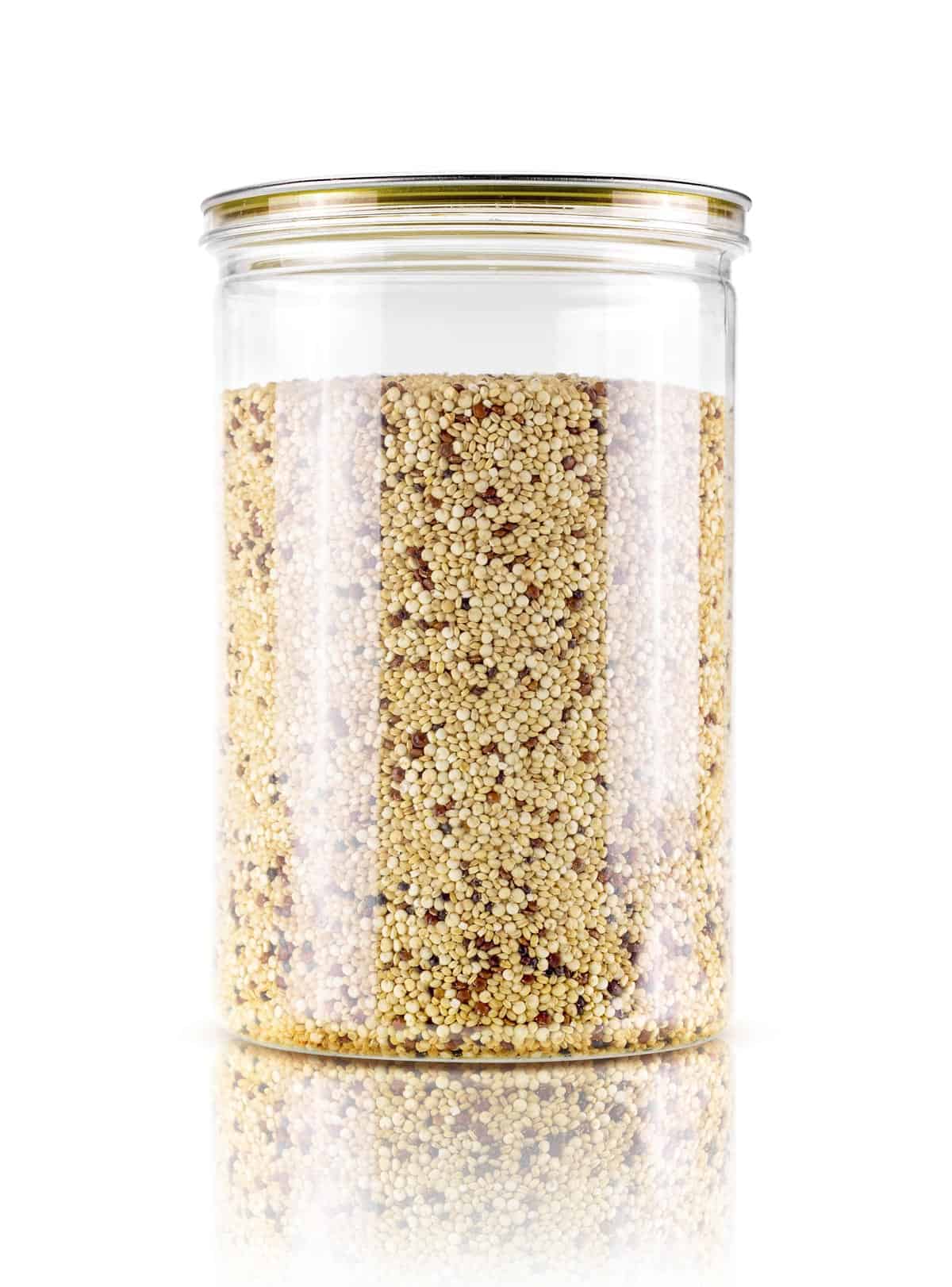 Tall glass storage jar of tri-color quinoa.