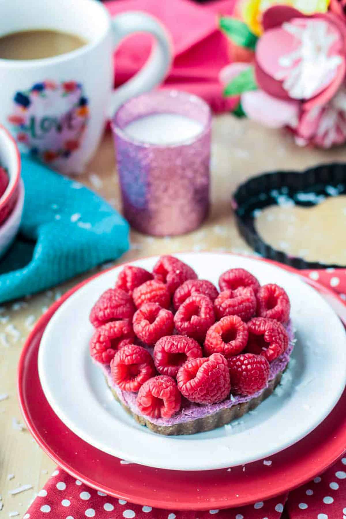 Fresh raspberries covering the top of a heart shaped tart.